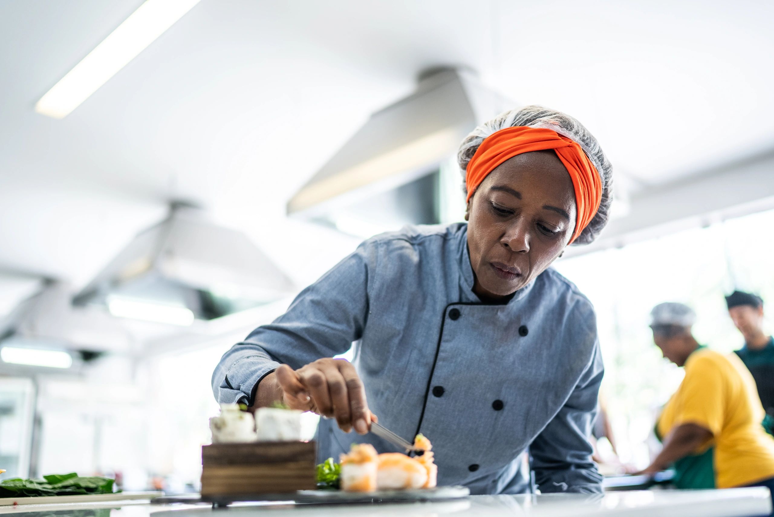 Cook plating a dish with microgreens garnish
